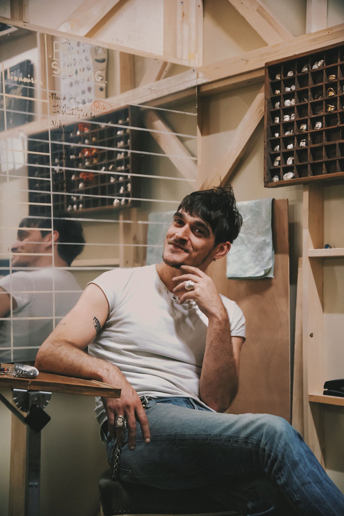 Edouard assis dans l'atelier, bagues aux doigts